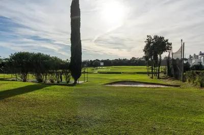 a golf course with palm trees and a green field at Apartamento Luna - Golf View By Dalma Portuguesa in Albufeira