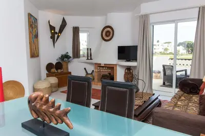 a living room with a table and a couch at Apartamento Luna - Golf View By Dalma Portuguesa in Albufeira