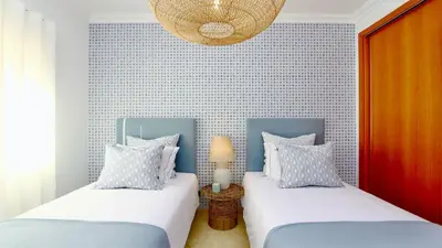 a bedroom with two beds and a chandelier at Adam's Place (Garça Real)CD242 - Clever Details, Sleeps 4 people, Wifi, Garage in Vilamoura