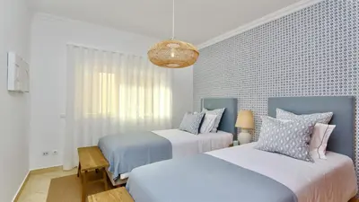 a bedroom with two beds and a chandelier at Adam's Place (Garça Real)CD242 - Clever Details, Sleeps 4 people, Wifi, Garage in Vilamoura