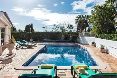 a swimming pool in a backyard with chairs and a table at Celina by Algarve Villa Holidays in Guia