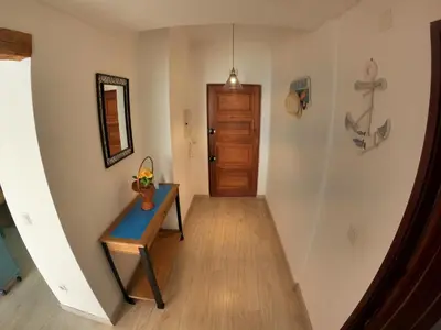 a hallway with a table and a door at Algarve, modern T1 apartment with balcony, Quarteira in Quarteira