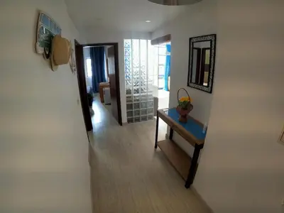 a hallway with a table and a mirror on a wall at Algarve, modern T1 apartment with balcony, Quarteira in Quarteira