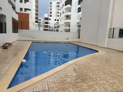 a swimming pool in the middle of a building at Algarve, modern T1 apartment with balcony, Quarteira in Quarteira