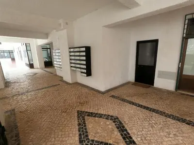 an empty room with a tile floor and a building at Algarve, modern T1 apartment with balcony, Quarteira in Quarteira