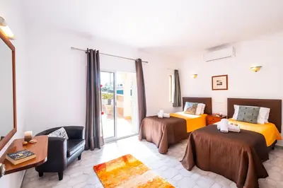 a hotel room with two beds and a couch at Villa Canguu by Algarve Vacation in Albufeira