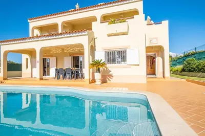a villa with a swimming pool in front of a house at Villa Canguu by Algarve Vacation in Albufeira
