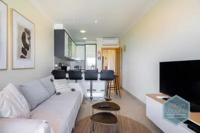 a living room with a couch and a flat screen tv at Quinta do Pinheiro Residence AN - Dream Lodging in Albufeira