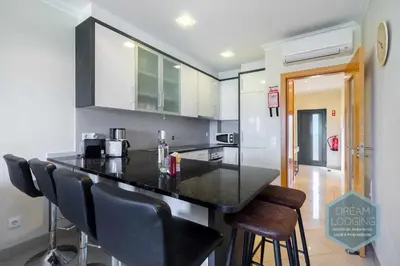 a kitchen with a black counter and stools at Quinta do Pinheiro Residence AN - Dream Lodging in Albufeira