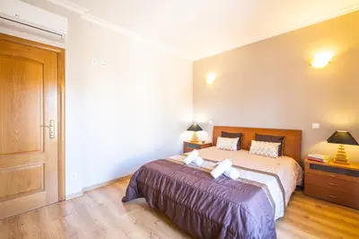 a bedroom with a large bed and a wooden floor at Villa Hawaii by Algarve Vacation in Albufeira