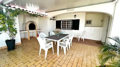 a patio with a table and white chairs at Villa Gilsónia by Sunny Deluxe in Guia