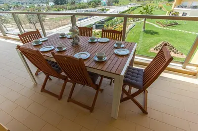 a wooden table and chairs on a balcony at Apartment Aria - Great area for children in Albufeira