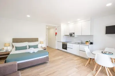 a large bedroom with a bed and a kitchen at Studio Pimenta - Short walk to the beach in Albufeira