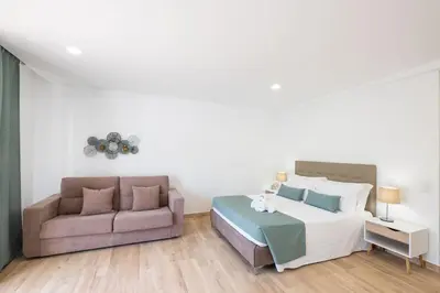 a bedroom with a bed and a couch at Studio Pimenta - Short walk to the beach in Albufeira
