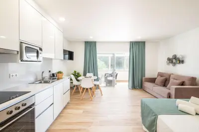 a kitchen and living room with a couch and a table at Studio Pimenta - Short walk to the beach in Albufeira