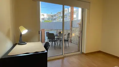 a room with a desk and a glass door with a table and chairs at Oura Oasis A by Check-in Portugal in Albufeira