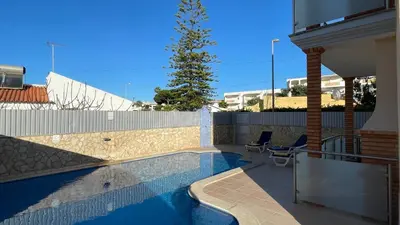 a swimming pool with two chairs next to a house at Oura Oasis A by Check-in Portugal in Albufeira
