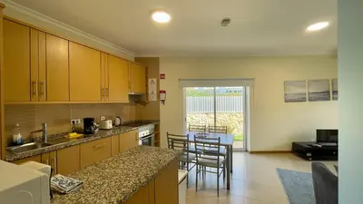 a kitchen with wooden cabinets and a counter top at Oura Oasis A by Check-in Portugal in Albufeira