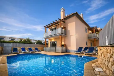 a villa with a swimming pool and blue chairs at Oura Oasis B by Check-in Portugal in Albufeira