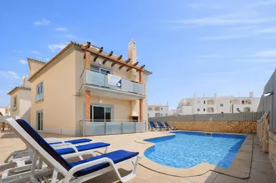 a villa with a swimming pool and lounge chairs at Oura Oasis C by Check-in Portugal in Albufeira