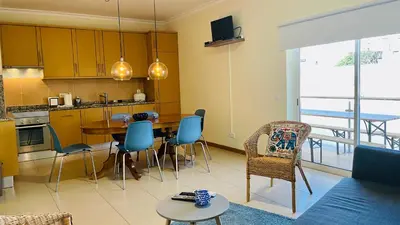 a kitchen and living room with a table and chairs at Oura Oasis C by Check-in Portugal in Albufeira