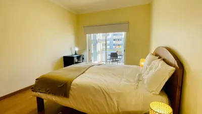 a bedroom with a bed with a window and a chair at Oura Oasis D by Check-in Portugal in Albufeira
