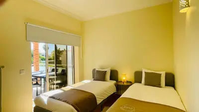 two beds in a room with yellow walls at Oura Oasis E by Check-in Portugal in Albufeira