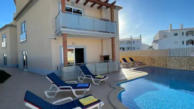 a patio with chairs and a swimming pool at Oura Oasis E by Check-in Portugal in Albufeira