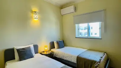 a small room with two beds and a window at Oura Oasis E by Check-in Portugal in Albufeira