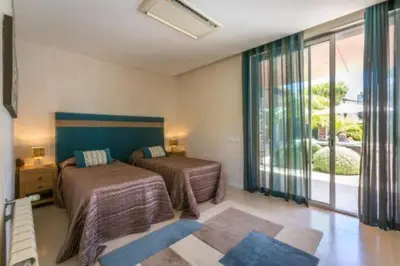 a bedroom with two beds and a large window at Villa Atlantic Pearl - Luxury villa located in in Quinta do Lago