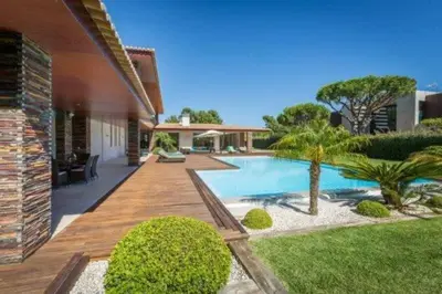 a backyard with a swimming pool and a house at Villa Atlantic Pearl - Luxury villa located in in Quinta do Lago