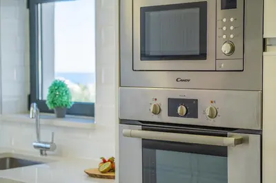 a kitchen with a microwave above a stove at Villa Blue Lagoon by Algarve Vacation in Albufeira