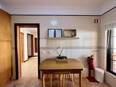a kitchen with a table and chairs in a room at Vilamoura Paradise Golf With Pool by Homing in Vilamoura