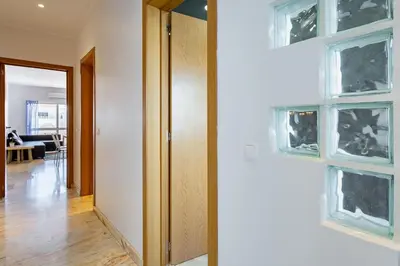 a hallway with a door and two windows at Duas Palmeiras by LovelyStay in Albufeira