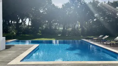 a swimming pool in a yard with a wooden deck at Azaleas by Check-in Portugal in Vilamoura