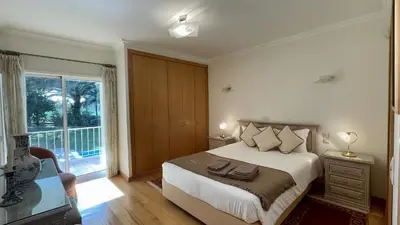 a bedroom with a bed and a large window at Azaleas by Check-in Portugal in Vilamoura