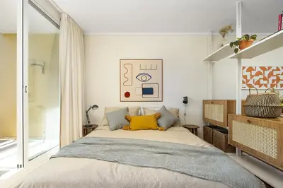 a bedroom with a large bed with yellow pillows at Estúdio do Largo - Vilamoura in Vilamoura