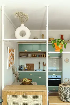 a kitchen with green cabinets and a table with fruits at Estúdio do Largo - Vilamoura in Vilamoura