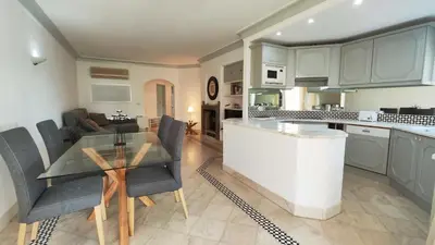 a kitchen and living room with a table and chairs at Sao Rafel Beach house in Albufeira