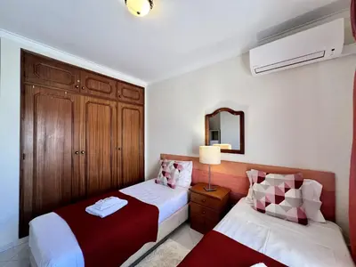 a bedroom with two beds and a mirror at Vilamoura Garden View 1 With Pool by Homing in Vilamoura