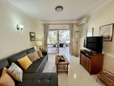a living room with a couch and a flat screen tv at Vilamoura Garden View 1 With Pool by Homing in Vilamoura