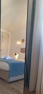 a bedroom with a bed and a mirror at Timi's House - Espaçoso apartamento a 350 m da praia e centro da cidade velha in Albufeira