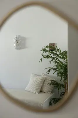 a mirror reflection of a couch with a plant at Timi's House - Espaçoso apartamento a 350 m da praia e centro da cidade velha in Albufeira