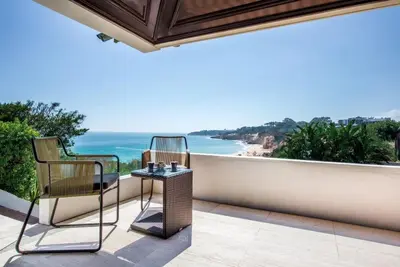 two chairs and a table on a balcony overlooking the ocean at Villa Plage Grande - Superstar luxury - Beachtop in Olhos de Água