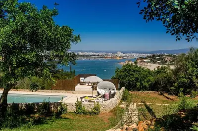a swimming pool with a view of a body of water at Villa Colom in Quarteira