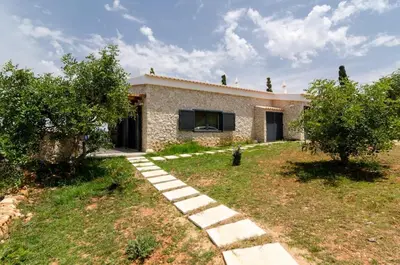a stone house with a garden in front of it at Villa Colom in Quarteira