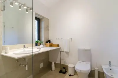 a bathroom with a toilet and a sink and a mirror at Villa Colom in Quarteira
