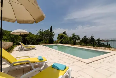a swimming pool with chairs and an umbrella at Villa Colom in Quarteira