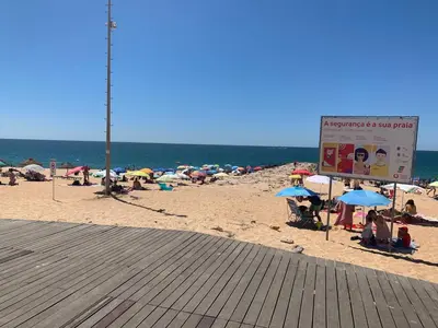 a group of people on a beach with umbrellas at Eine Wohnung für den perfekten Urlaub !!! in Quarteira