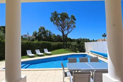 a pool with chairs and a table next to a house at Spacious Vilamoura Villa 4 Bedrooms Villa Amendoeira Table Tennis in Quarteira